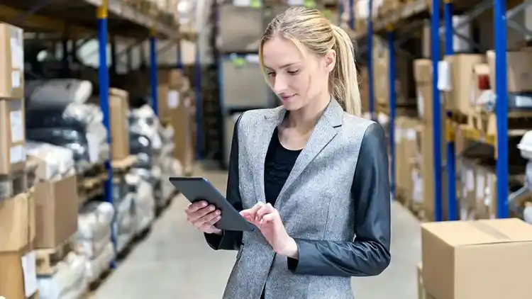 Woman looking at iPad in warehouse