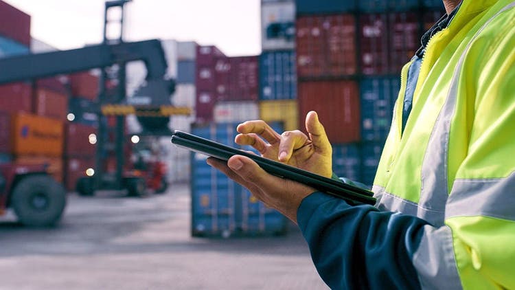 man in freight yard with tablet