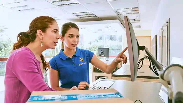 Un empleado de UPS ayuda a un cliente a enviar un paquete.
