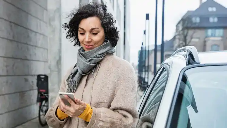 Kvinna på gatan tittar på telefon