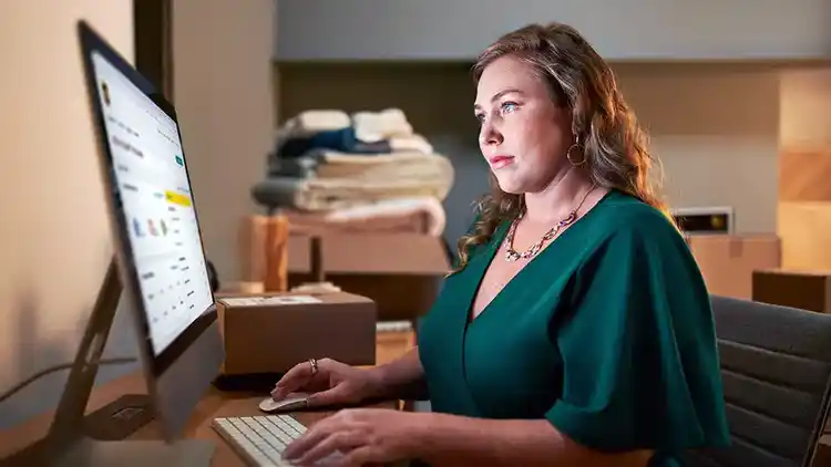 Kvinna som bär grön klänning tittar på ett skrivbord